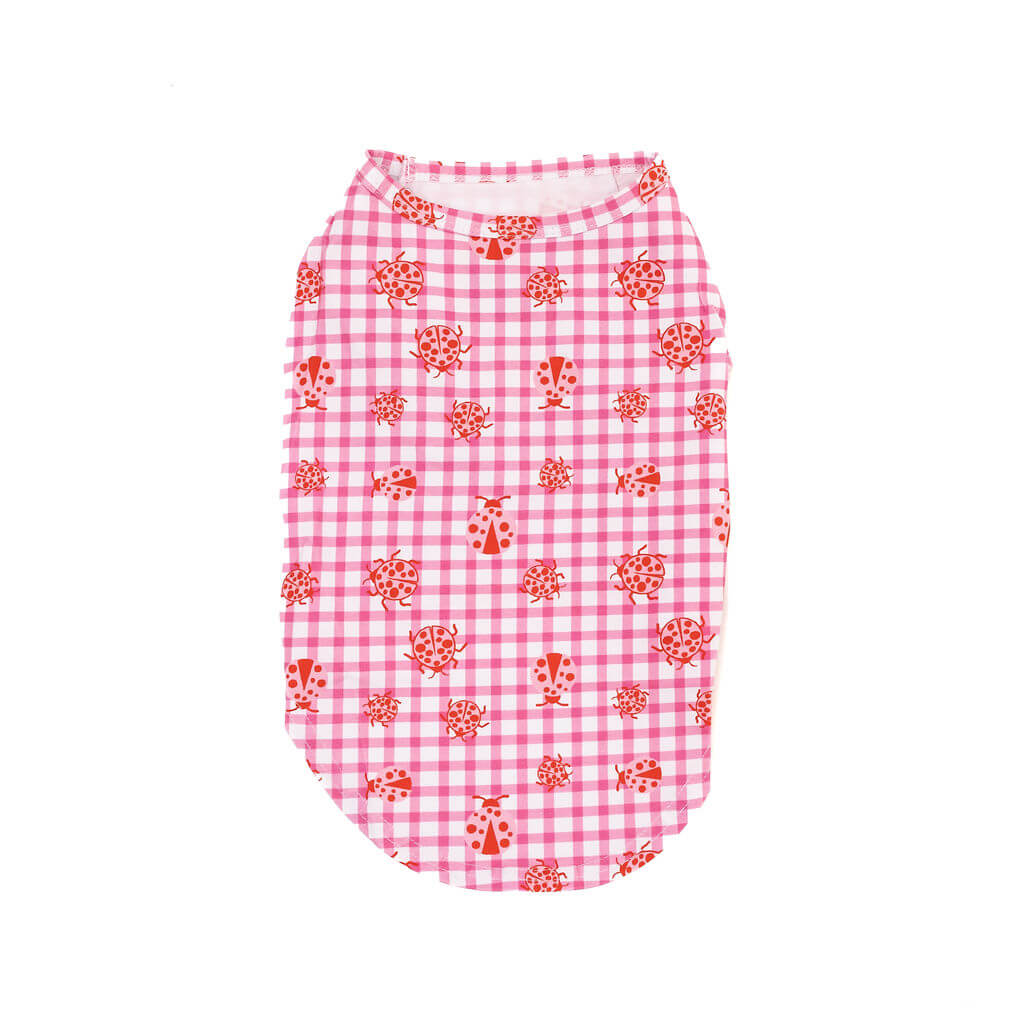 Flat lay of the back of a pink gingham dog shirt with red ladybug print, displayed on a white background.