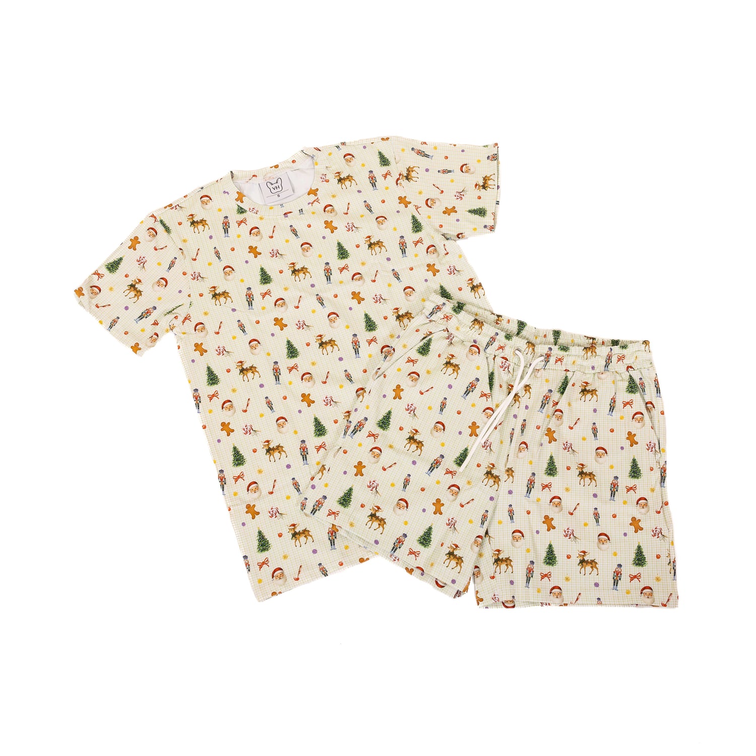 Flat lay of Santa’s Workshop matching human Christmas pyjamas, featuring a cream set with Santa, reindeer, nutcrackers, candy canes and Christmas trees.