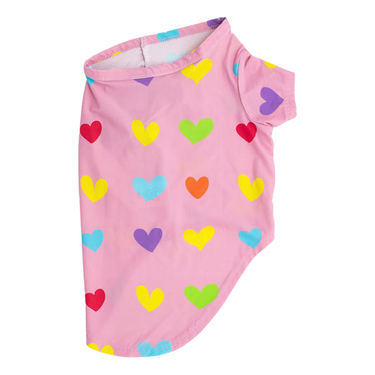 A side flat lay of a pink shirt with orange, blue, yellow, and green love hearts printed on it.  This shirt for dogs is designed to be wet to cool dogs down.