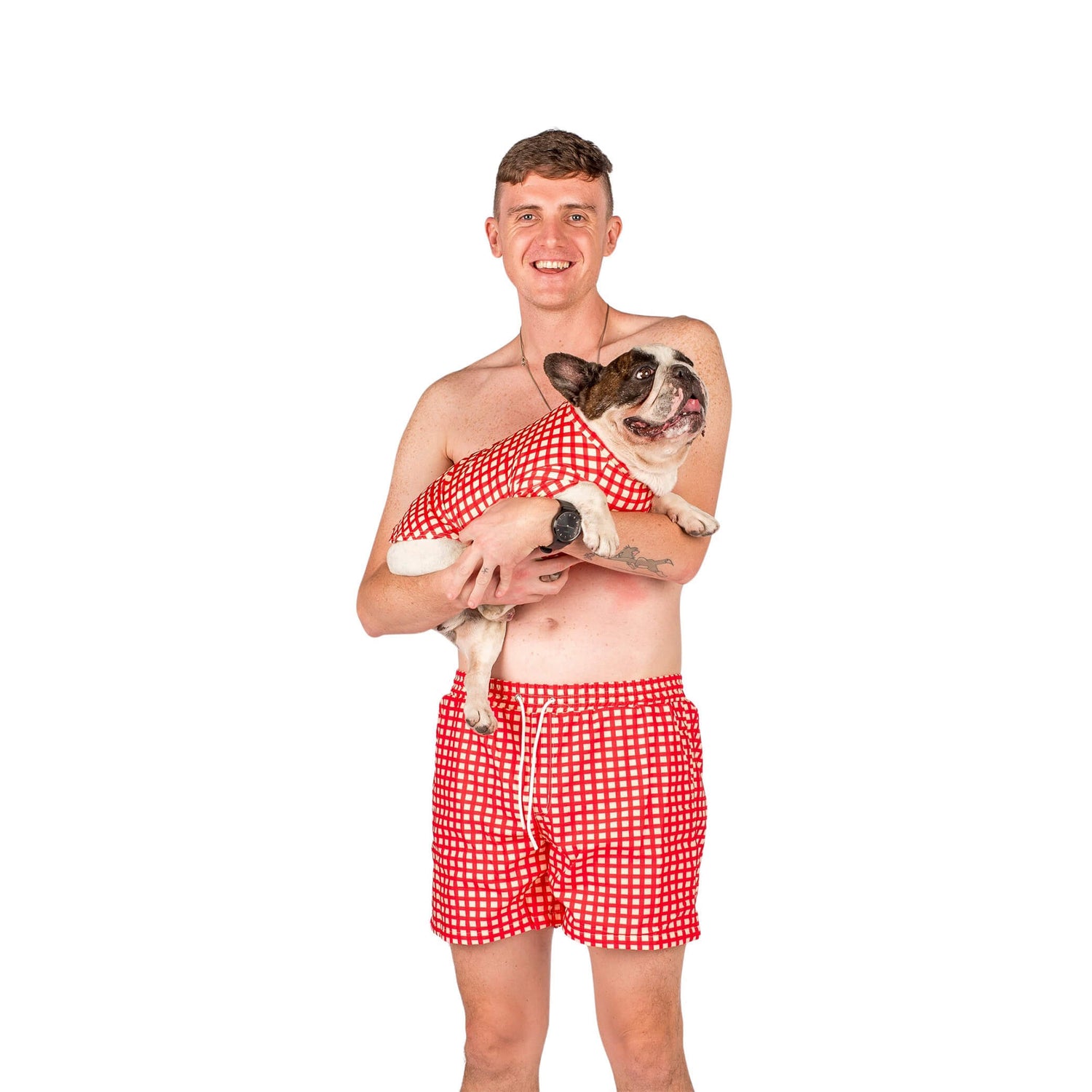 French Bulldog and Male model wearing matching Vibrant Hound Red Gingham swimwear.